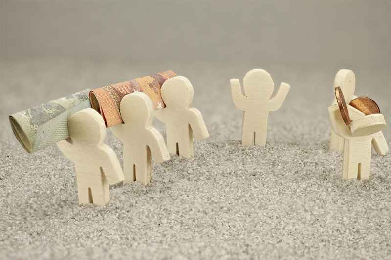 Kleine Figuren mit Geldscheinen und Münzen