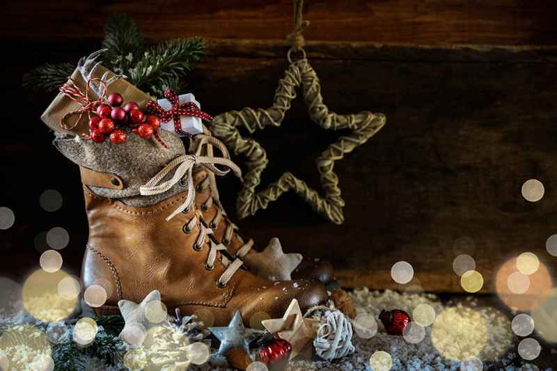 Rustikaler Hintergrund mit Stiefel und Geschenk